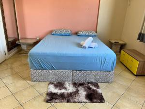 een slaapkamer met een bed met blauwe lakens en een tapijt bij Apartamento no Centro da Cidade in Belém