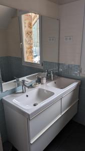 een badkamer met een witte wastafel en een spiegel bij Charming millstone house btw Paris & Versailles in Chaville
