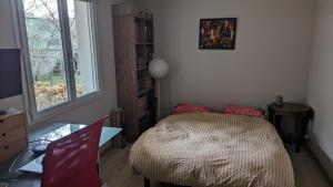 een slaapkamer met een bed, een bureau en een raam bij Charming millstone house btw Paris & Versailles in Chaville