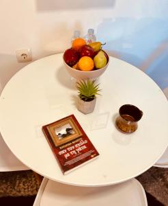 a table with a bowl of fruit and a book at S&A Modern Apartment in Igoumenitsa +18 photos