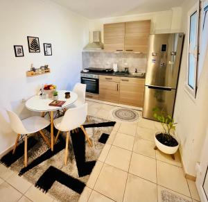 a kitchen with a table and chairs and a refrigerator at S&A Modern Apartment in Igoumenitsa
