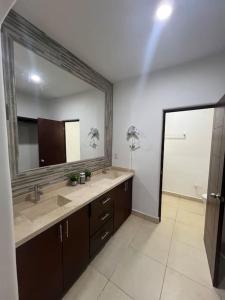 baño con 2 lavabos y espejo grande en Casa Portobello, en La Paz