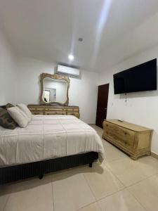 1 dormitorio con cama, espejo y TV en Casa Portobello, en La Paz