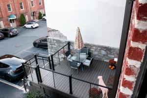 a balcony with a table and chairs and an umbrella at Sweet Lancaster Apt. A in Lancaster