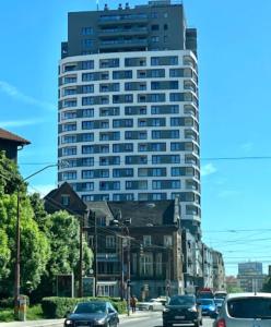 ein hohes Gebäude mit Autos, die eine Stadtstraße hinunterfahren in der Unterkunft Quietly oriented apartment with free parking and balcony in Bratislava
