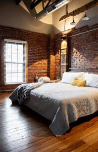 a bedroom with a large bed in a brick wall at Sweet Lancaster Apt. A in Lancaster