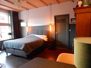 a bedroom with a bed and a table with chairs at Gasthuis In de Heilige Stede in Hasselt