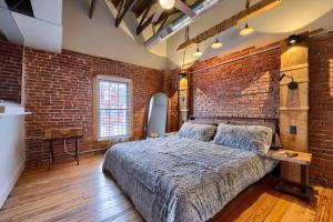 um quarto com paredes de tijolos, uma cama e uma parede de tijolos. em Sweet Lancaster Suite em Lancaster