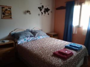 a bedroom with a bed with two towels on it at La Nona in El Carmen