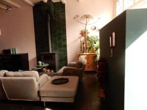 a living room with two couches and a fireplace at Gasthuis In de Heilige Stede in Hasselt