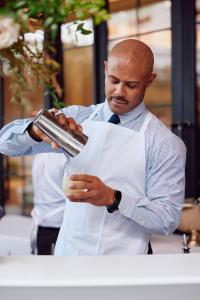 mężczyzna w garniturze i krawacie trzymający drinka w obiekcie The Global Ambassador w mieście Phoenix