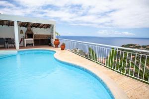 een zwembad op het balkon van een huis met uitzicht op de oceaan bij Villa Margarida in Ponta do Sol