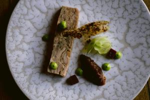 a white plate with a piece of bread and green olives at Haweswater Hotel in Bampton