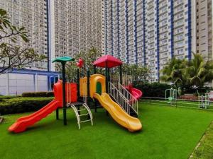 einen Spielplatz mit Rutsche in einem Park in der Unterkunft Entire 1-Bedroom Condo in Makati in Manila