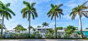 棕櫚灘海岸的住宿－Sunshine shores boutique apartments，一排棕榈树在房子前面