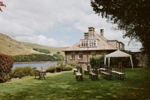 ein Haus mit Tischen und Stühlen davor in der Unterkunft Haweswater Hotel in Bampton