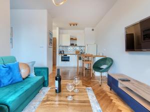 a living room with a couch and a table with wine glasses at Gdańsk Amber Suite with Parking by Rentujemy in Gdańsk