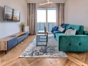 a living room with a green couch and a table at Gdańsk Amber Suite with Parking by Rentujemy in Gdańsk