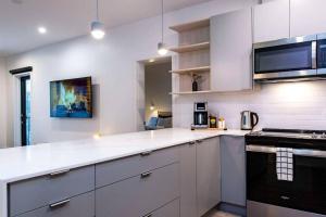 a kitchen with white cabinets and a stove top oven at Tumbledown Condo by Revelstoke Vacations in Revelstoke