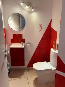 a red and white bathroom with a toilet and a sink at Villa moderne avec piscine dans impasse au calme in Clapiers