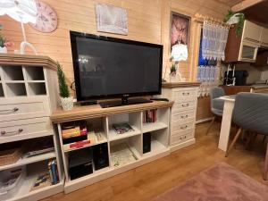 a living room with a television on a white entertainment center at Ustronne Chatki - Ostoja nad Potokiem in Ustroń