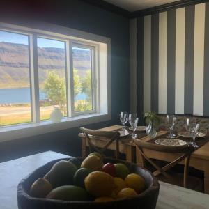 a dining room with a bowl of fruit on a table at Sea, fjord & mountain view house in Súðavík
