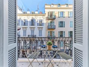 Habitación con vistas a un balcón con mesa y sillas. en Luxury Homeplace in Nice Center, en Niza