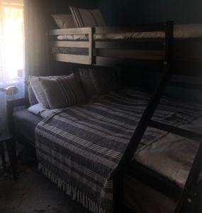 a bedroom with a bunk bed with a striped blanket at Sea, fjord & mountain view house in Súðavík