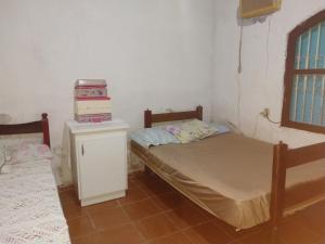 um quarto com duas camas e uma máquina num balcão em Aconchego em Caraguatatuba