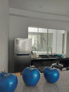 deux pommes bleues assises sur un comptoir dans une cuisine dans l'établissement Departamento de playa amoblado, à Cerro Azul