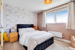 een slaapkamer met een groot bed en een raam bij Modern 2 bed 2 bath with Balcony in Rayners lane Pinner Harrow near Wembley Greater London in Pinner