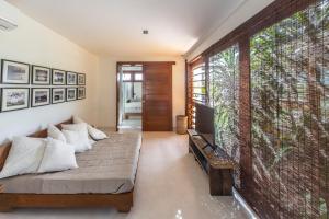 a bedroom with a bed and a large window at Luxury & Design in Praia do Forte in Praia do Forte