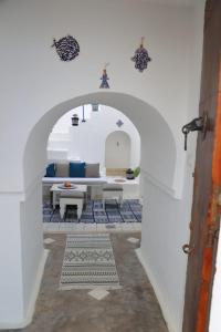 an archway with a table and chairs in a room at Dar Ali Médina Hammamet chambres d'hôtes in Hammamet