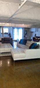 een woonkamer met witte banken in een kamer bij Huge Downtown LA Loft with Rooftop Pool & Jacuzzi in Los Angeles