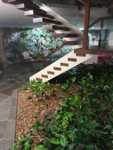 a garden with a staircase in a building with plants at Mansão Mar casado in Guarujá
