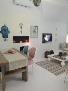 un soggiorno bianco con tavolo e sedie di Dar Azur Hammamet Guest House a Hammamet