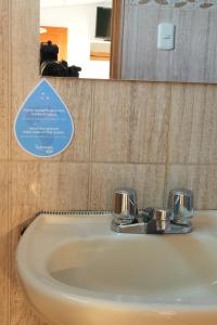 a sink in a bathroom with a sign above it at MATARA GREENS HOTEL in Cusco +33 photos