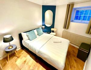 ein Schlafzimmer mit einem großen Bett mit blauen Wänden in der Unterkunft Doric apartment in London