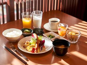 a wooden table with a plate of food and drinks at Daiwa Roynet Hotel Hiroshima in Hiroshima