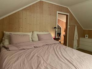 un grande letto in una camera da letto con pareti in legno di 54:an - flott rekkehus med gangavstand til sentrum a Røros