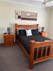 a bedroom with a wooden bed and two night stands at Echuca Retreat Holiday House in Echuca