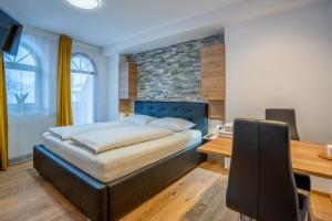 a bedroom with a large bed and a desk and a table at TEMPFER Apartments & Rooms with new WELLNESS in Rateče
