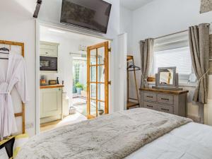 a bedroom with a bed and a kitchen at 1 Bed in Lanhydrock 88165 in Bodmin