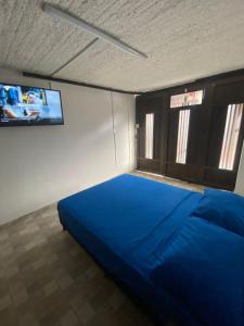 a large blue bed in a room with two windows at Hermoso apartamento en San Pablo Guayabal in Medellín