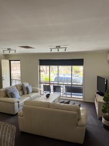 a living room with two couches and a tv at Echuca Retreat Holiday House in Echuca
