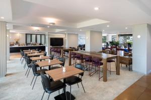 a restaurant with tables and chairs and a bar at Mercure Sydney Blacktown in Blacktown