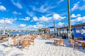 un patio con mesas y sillas en la playa en North Lost Key Landing 2B, en Pensacola