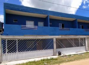a blue building with a fence in front of it at Residencial Praia Quente casas in Nova Viçosa