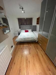 um quarto com uma cama e piso em madeira em Deluxe Room En-suite Free Parking em Seven Kings