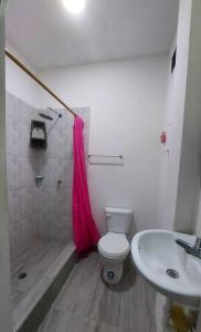 La salle de bains est pourvue de toilettes et d'un lavabo. dans l'établissement Hospedaje Casa San Pablo, à Santa Elena